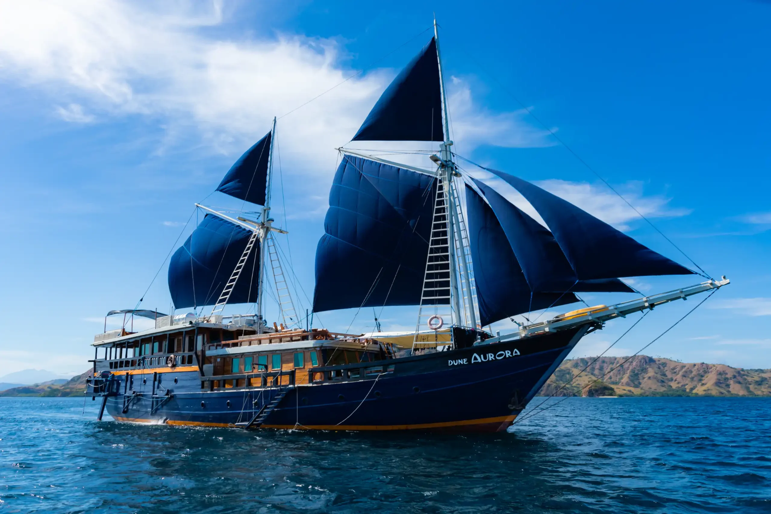 Le phinisi Dune Aurora naviguant sous ses voiles bleues